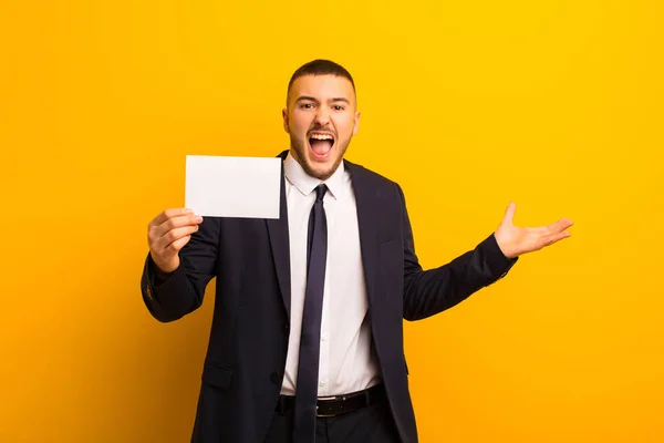 Joven Hombre Negocios Guapo Sobre Fondo Plano Con Una Pancarta — Foto de Stock