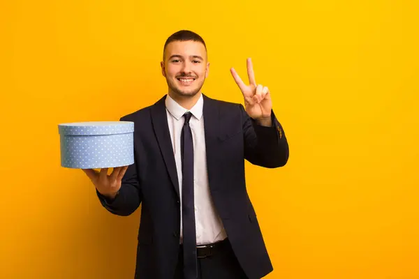 Jovem Bonito Empresário Contra Plano Fundo Com Uma Caixa Presente — Fotografia de Stock