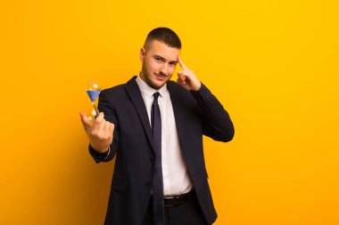 Kum saati zamanlayıcısı olan genç ve yakışıklı bir iş adamı.