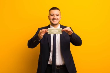 Genç ve yakışıklı iş adamı düz fon para kavramına karşı