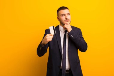 Genç ve yakışıklı iş adamı düz fon para kavramına karşı