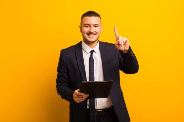 Genç yakışıklı iş adamı tabletle arka planda yaşıyor.