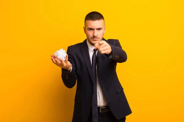 young handsome businessman  against flat background with a wrinkled paper