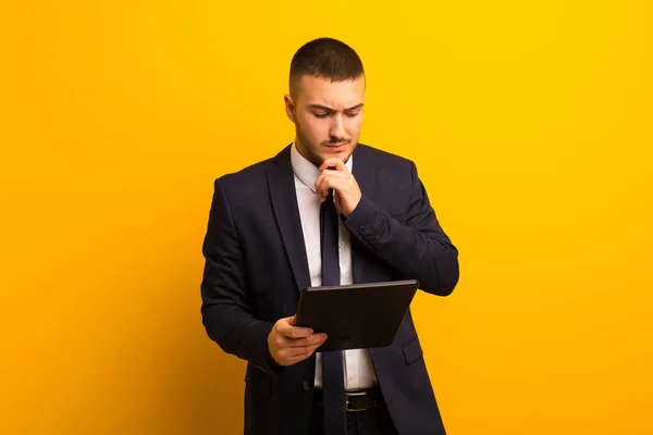 young handsome businessman  against flat background with a tablet