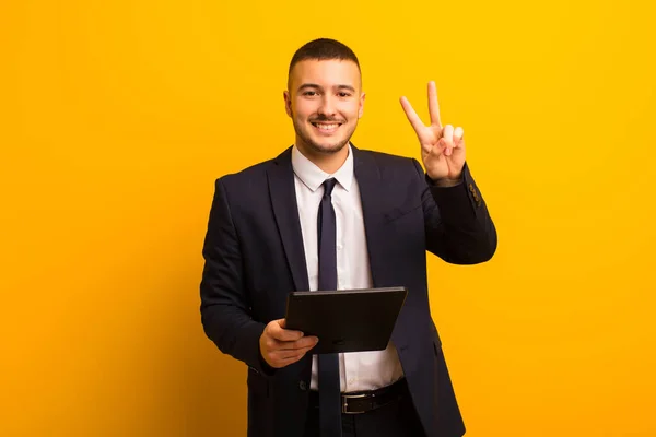 Giovane Uomo Affari Bello Contro Sfondo Piatto Con Una Tavoletta — Foto Stock