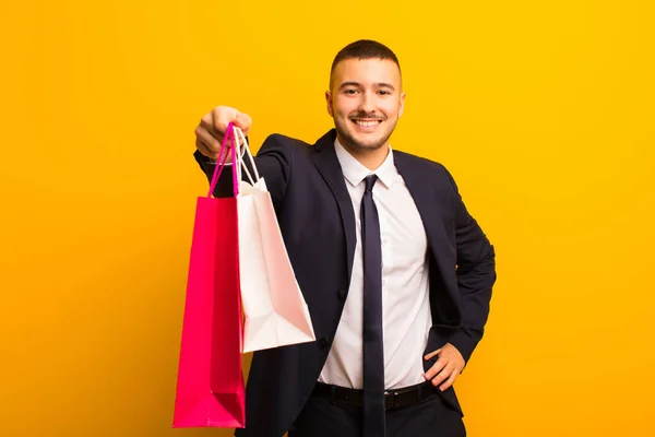 Joven Hombre Negocios Guapo Contra Fondo Plano Con Bolsas Compras —  Fotos de Stock