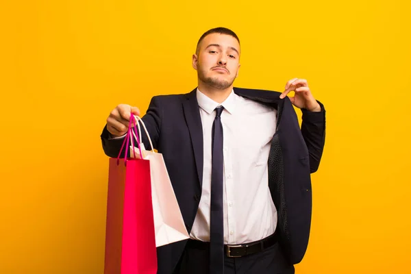 Joven Hombre Negocios Guapo Contra Fondo Plano Con Bolsas Compras —  Fotos de Stock