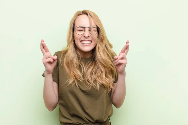 Jovem Mulher Loira Bonita Sentindo Nervosa Esperançosa Cruzando Dedos Orando — Fotografia de Stock