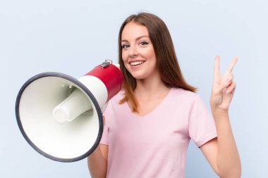 Genç kızıl saçlı kadın düz duvara karşı megafonla