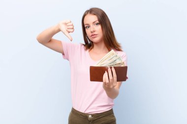 Genç kızıl saçlı kadın düz duvar parası kavramına karşı.