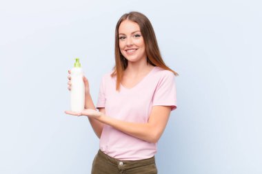 Genç kızıl saçlı kadın düz duvara karşı kozmetik kremle