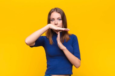 Genç kızıl saçlı kadın ciddi, sert, kızgın ve hoşnutsuz görünüyor.