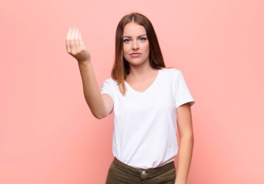 Genç kızıl saçlı kadın kapiş ya da para hareketi yapıyor, sana borçlarını ödemeni söylüyor! yassı duvara karşı