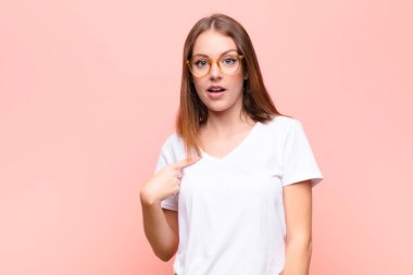 Genç kızıl saçlı kadın şaşkın, şaşkın ve güvensiz hissediyor. Kendini gösterip kim olduğumu soruyor. Ben mi? yassı duvara karşı