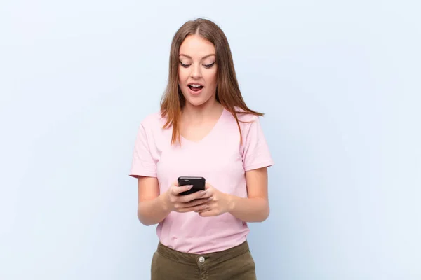 Joven Cabeza Roja Mujer Contra Pared Plana Con Teléfono Inteligente —  Fotos de Stock