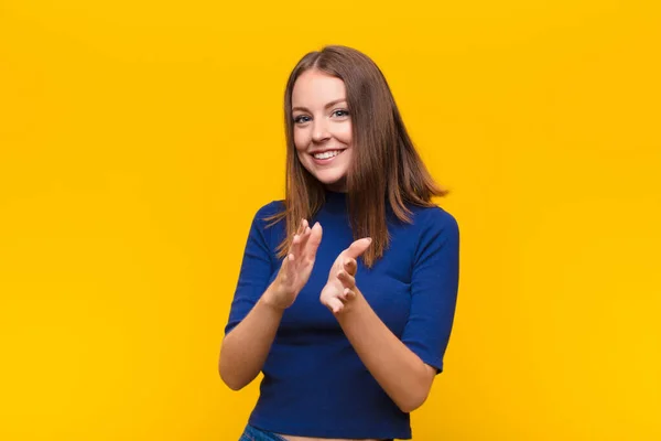 若い赤い頭の女性は幸せと成功を感じ笑顔と拍手の手フラットウォールに対する拍手でお祝いを言います — ストック写真