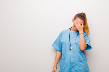 Genç Latin hemşire stresli, utanmış ya da üzgün görünüyordu. Başı ağrıyordu. Yüzü bembeyaz duvara dönmüştü.