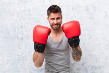 Genç adam düz renk duvar sporu kavramına karşı boks yapıyor.