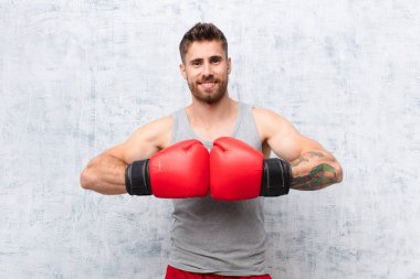 Genç adam düz renk duvar sporu kavramına karşı boks yapıyor.