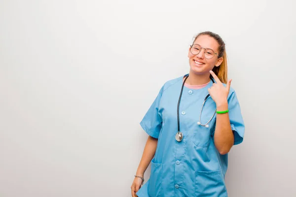 Junge Lateinische Krankenschwester Lächelt Selbstbewusst Und Zeigt Auf Ihr Eigenes — Stockfoto