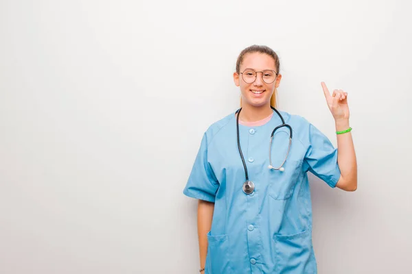 Молода Латинська Медсестра Усміхається Весело Щасливо Вказуючи Вгору Однією Рукою — стокове фото