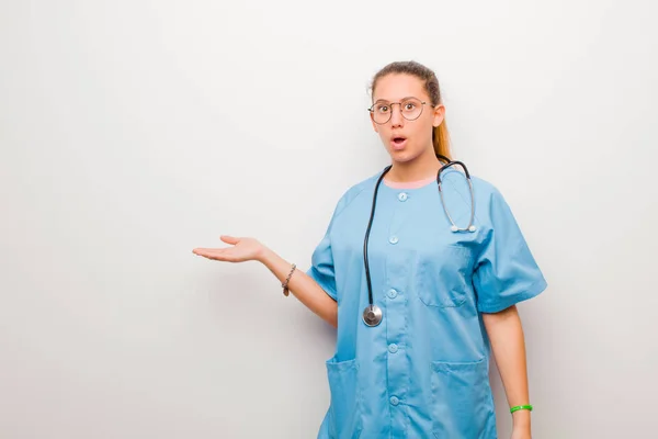 Young Latin Nurse Looking Surprised Shocked Jaw Dropped Holding Object — 스톡 사진
