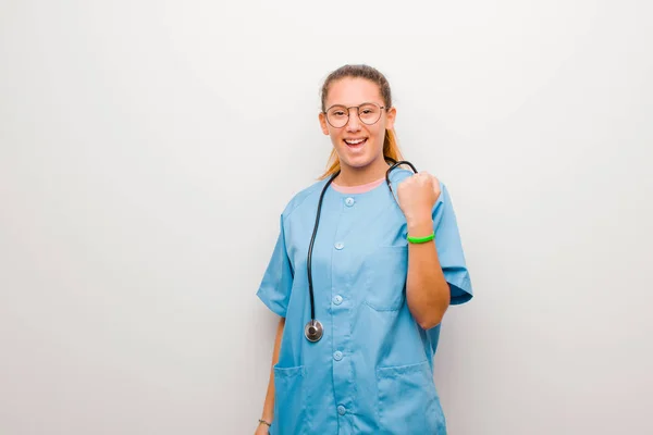 ラテン語の若い看護師は白い壁に対する成功を祝いながら笑いと喜びと興奮を叫び — ストック写真