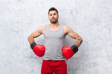 Genç adam düz renk duvar sporu kavramına karşı boks yapıyor.