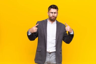 Kötü tavırlı genç adam gururlu ve agresif görünüyor, yukarı bakıyor ya da duvarlara yaslanmış ellerle dalga geçiyor.