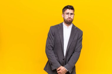 Şapşal, çılgın, şaşırmış yüz ifadesiyle genç handome adam, şişmiş yanaklar, doldurulmuş hissetmek, şişman ve düz renkli duvarlara karşı yemek dolu.