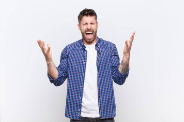 Genç adam öfkeyle bağırıyor, strese giriyor ve ellerini havaya kaldırıp neden düz duvara yaslandığımı söylüyor.