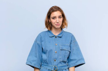 Genç sarışın kadın üzgün ve mızmızlanıyor, mutsuz bir bakışla, negatif ve hayal kırıklığına uğramış bir tavırla ağlıyordu.