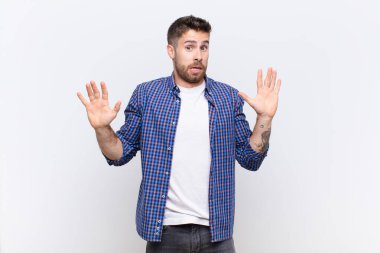 Genç adam gergin, endişeli ve endişeli görünüyor, benim hatam olmadığını söylüyor, yoksa düz renkli duvara karşı yapmazdım. 