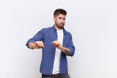 Genç adam tiksinti ve mide bulantısı hissediyor, pis kokan ya da kokan bir şeyden uzak duruyor, düz renkli duvara karşı iğrenç diyor.