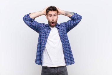 Genç adam heyecanlı ve şaşırmış görünüyor, iki eli başının üstünde ağzı açık, düz duvara karşı şanslı bir kazanan gibi hissediyor.