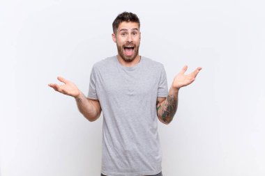 Genç adam mutlu, heyecanlı, şaşırmış, şaşırmış, gülümseyen ve şaşırmış hissediyor.