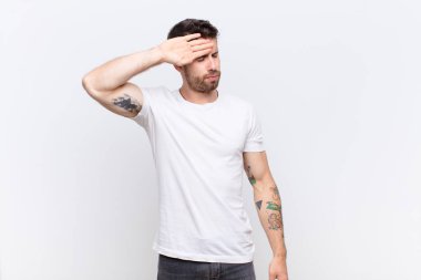 Genç adam stresli, yorgun ve hayal kırıklığına uğramış görünüyor, alnından ter damlıyor, umutsuz ve bitkin hissediyor.