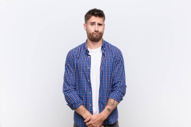 Genç Handome 'un kafası karışık ve kuşkulu, merak ediyor ya da düz renkli duvara karşı karar vermeye çalışıyor.