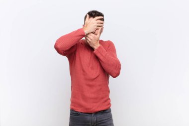 Genç adam kameraya hayır diyen iki eliyle yüzünü kapatıyor! Resimleri reddetmek ya da düz renkli duvara karşı resimleri yasaklamak