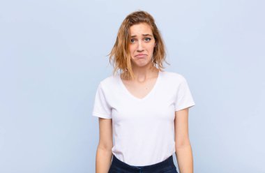 Genç sarışın kadın üzgün ve stresli. Kötü bir sürpriz yüzünden üzgün. Olumsuz, endişeli bir bakış.