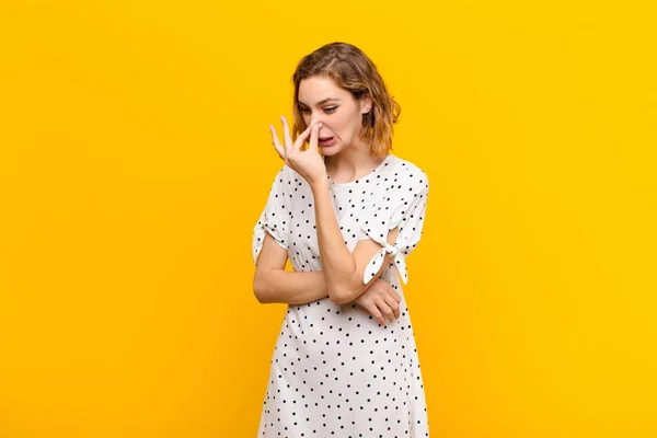 Young Blonde Woman Feeling Disgusted Holding Nose Avoid Smelling Foul — 스톡 사진