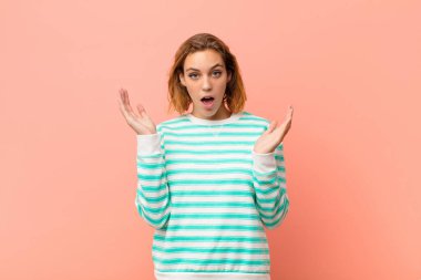 Genç sarışın kadın şok olmuş ve şaşırmış görünüyordu. Düz renkli duvara karşı inanılmaz bir şey fark ettiğinde, ağzı açık kalmıştı.