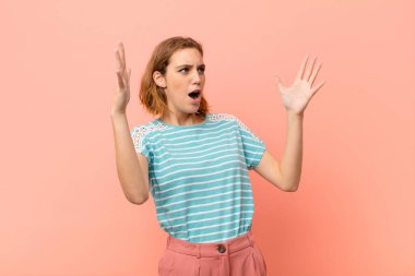 Genç sarışın kadın opera yapıyor ya da konserde şarkı söylüyor. Romantik, sanatsal ve tutkulu hissediyor. Düz renkli duvara karşı.