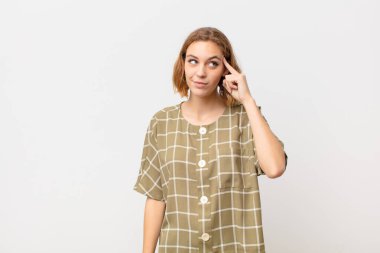 Genç sarışın kadın şaşırmış, ağzı açık, şok olmuş, düz renk duvara karşı yeni bir düşünce, fikir ya da konsept fark ediyor.