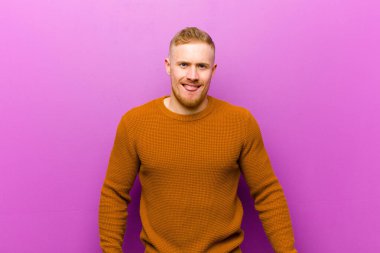 Genç, sarışın bir adam. Tiksinmiş ve rahatsız olmuş hissediyor. Dilini dışarı çıkarıyor.