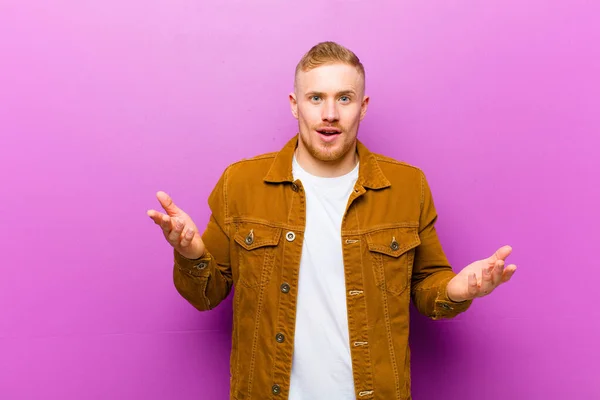 young blonde man open-mouthed and amazed, shocked and astonished with an unbelievable surprise against purple background