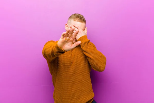 Jovem Loiro Vestindo Jumper Cobrindo Rosto Com Mão Colocando Outra — Fotografia de Stock