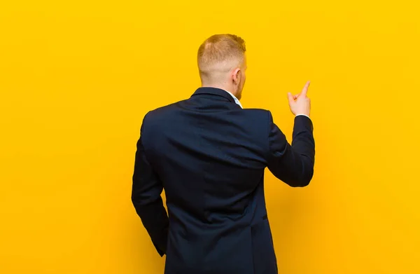 Young Blond Businessman Standing Pointing Object Copy Space Rear View — Stock Photo, Image