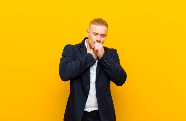 Genç sarışın işadamı boğazı ağrıdığı ve grip belirtileri gösterdiği için öksürüyor.