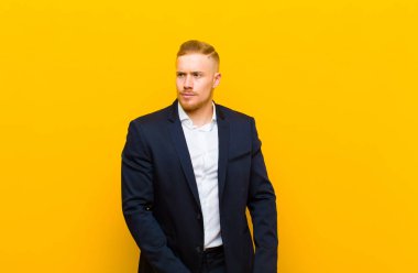 Genç sarışın iş adamı şaşkın, şaşkın ve şaşırmış hissediyor, elleri göğsünde ve ağzı açık, diyor ki, kim, ben?